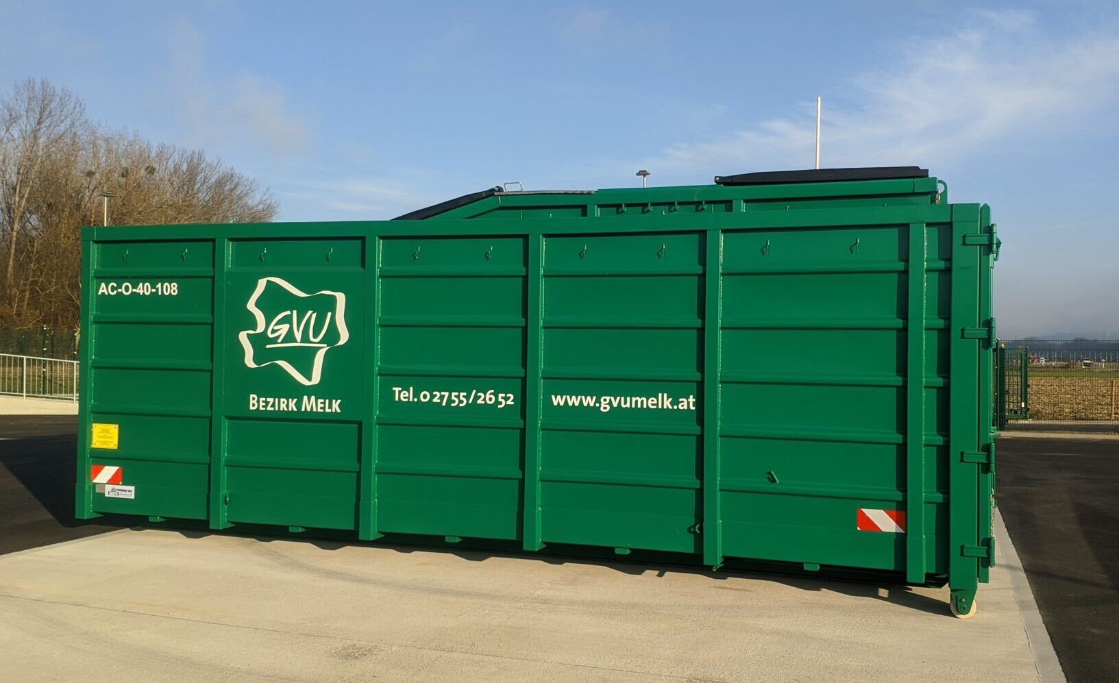 Am Bild ist ein 35 m³ Container in verbandstypischem Dunkelgrün mit dem Logo des GVU Melk an der Seitenwand zu sehen.